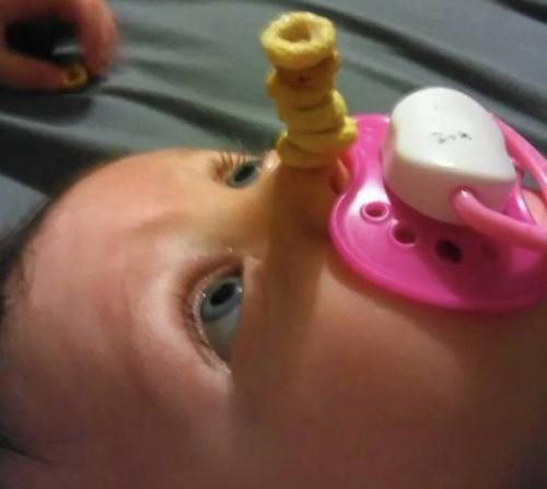 У американских папочек новый челлендж в соцсетях: кто сложит на своем спящем маленьком ребенке самую высокую башенку из сладких сахарных колечек. 01