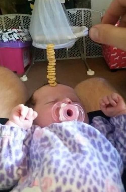 У американских папочек новый челлендж в соцсетях: кто сложит на своем спящем маленьком ребенке самую высокую башенку из сладких сахарных колечек. 03