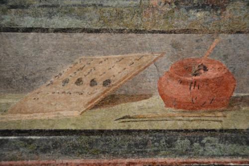 Дорожки маленьких черных пятен на боку чернильницы от пролитых капель чернил, такая точная деталь ухваченная художником!