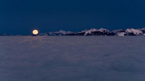 Суперлуние над долиной Рейна, укрытой морем облаков, и горными цепями в форарльберге, Австрия. 01